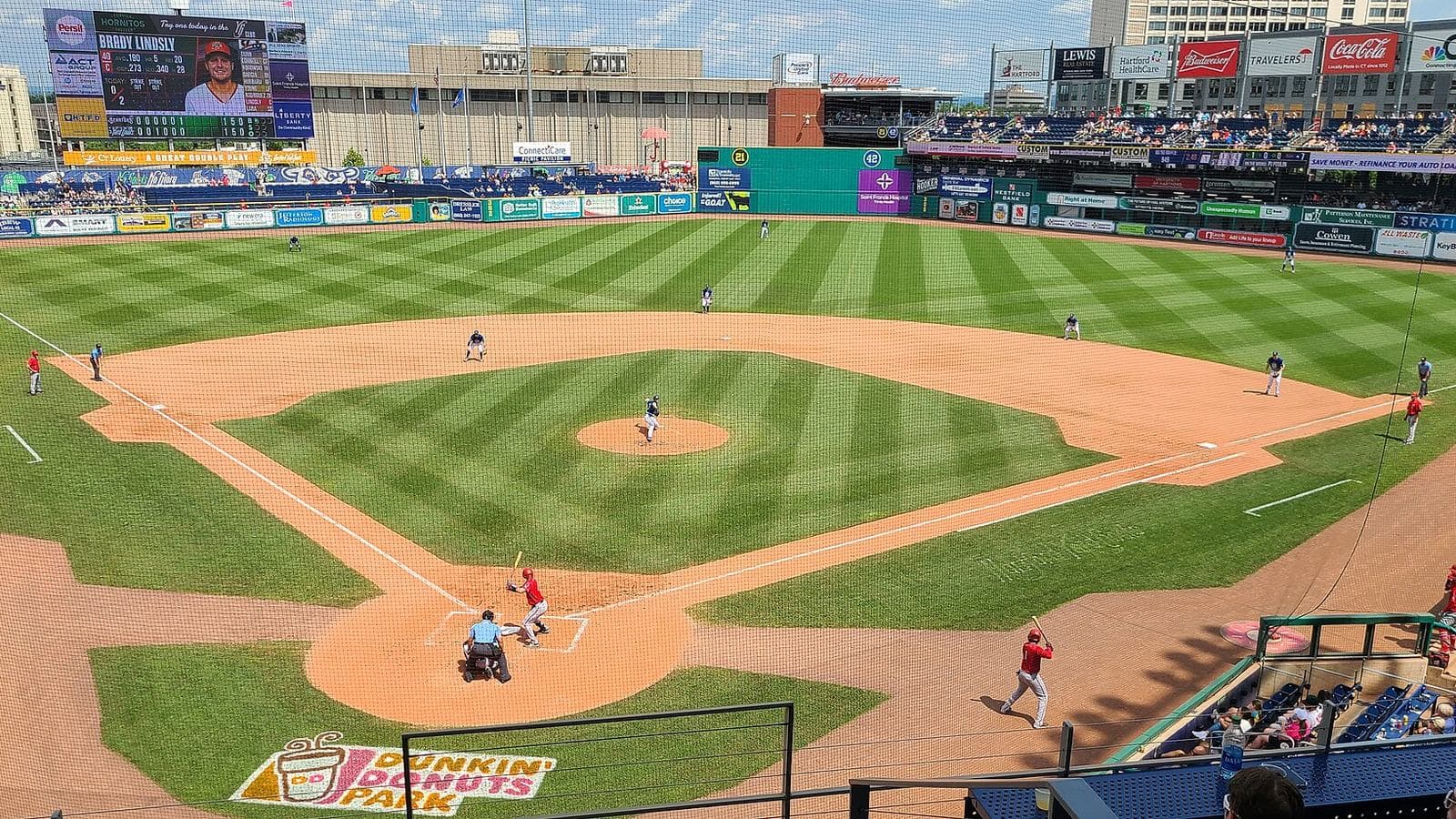 A Yard Goats game at Dunkin' Park, outfield wall lined with local sponsors