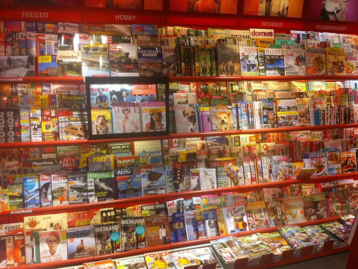 A newsstand rack full of printed magazines